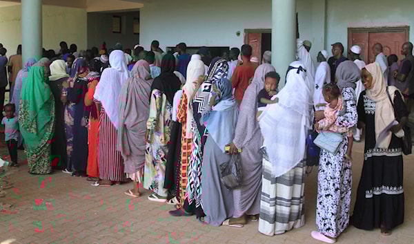 نسوة ينتظرن في صف للحصول على مساعدات في الخرطوم (أ ف ب)