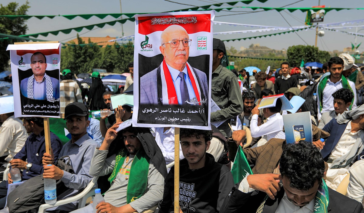يمنيون في صنعاء يرفعون صور رئيس الوزراء الراحل، أحمد الرهوي، الذي استشهد في غارة إسرائيلية الأسبوع قبل الماضي (أ ف ب)