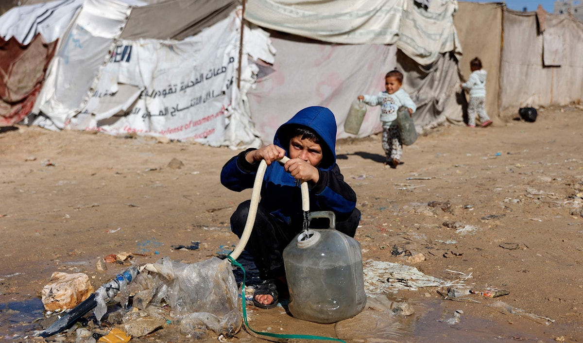 طفل فلسطيني نازح يملأ غالوناً  بالمياه في مدينة غزة (أ ف ب)