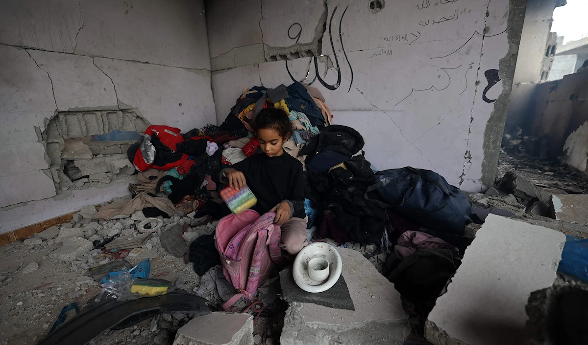 فتاة فلسطينية تضع أغراضها في حقيبتها في مخيم البريج في وسط قطاع غزة (أ ف ب)