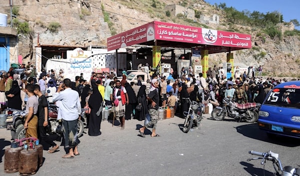 يمنيون ينتظرون في طوابير لملء اسطوانات غاز في إحدى محطات مدينة تعز (أ ف ب)