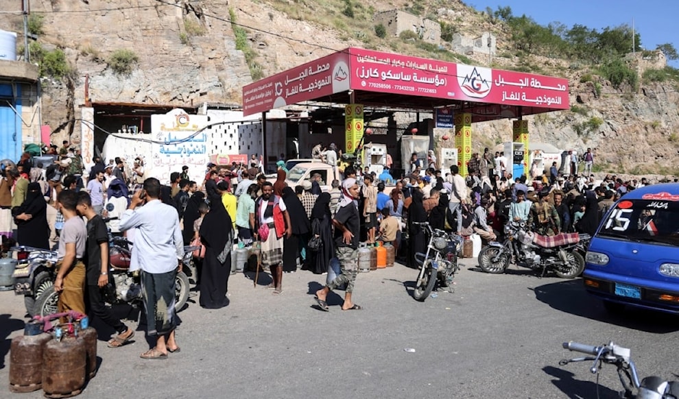 يمنيون ينتظرون في طوابير لملء اسطوانات غاز في إحدى محطات مدينة تعز (أ ف ب)