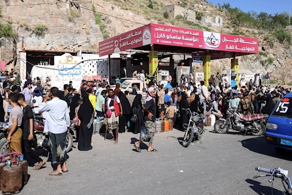 يمنيون ينتظرون في طوابير لملء اسطوانات غاز في إحدى محطات مدينة تعز (أ ف ب)
