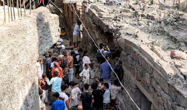 يمنيون يتجمعون في موقع انفجار صاروخ في إحدى مناطق المواجهات في تعز (أ ف ب)