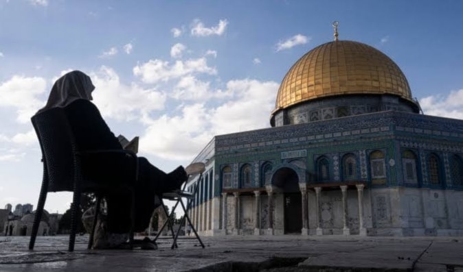 إمرأة تقرأ القرآن في باحة المسجد الأقصى في القدس المحتلة (أ ف ب)