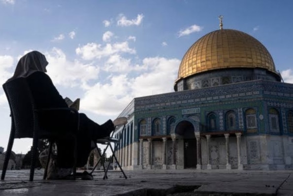 إمرأة تقرأ القرآن في باحة المسجد الأقصى في القدس المحتلة (أ ف ب)