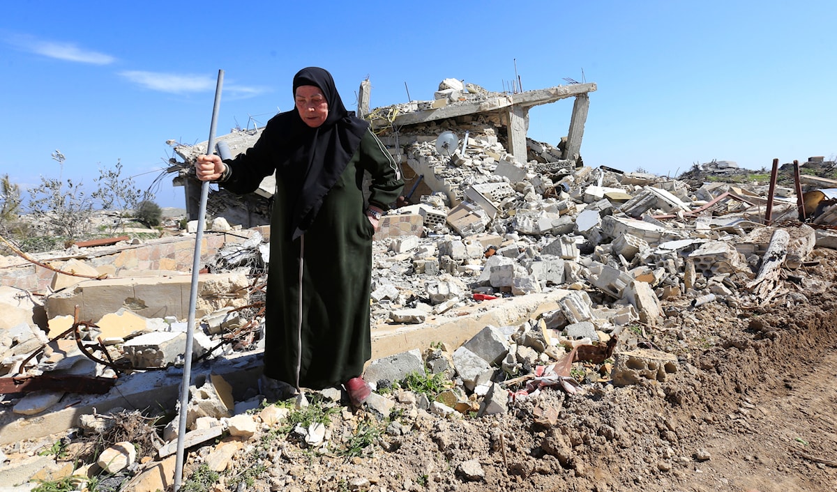 امرأة من أهالي قرية مارون الراس تتفقد بيتها المدمر (مروان بو حيدر)