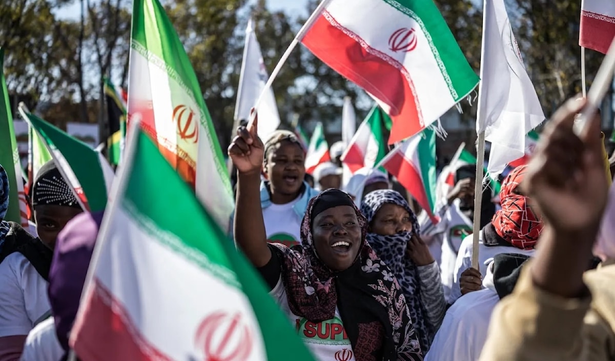 متظاهرون في بريتوريا يلوّحون بالأعلام الإيرانية أثناء تجمعهم أمام القنصلية الأميركية (أ ف ب)