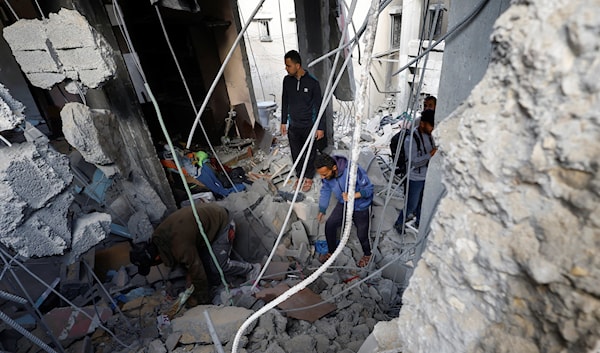 فلسطينيون يتفقّدون موقع غارة إسرائيلية في مخيم المغازي (من الويب)