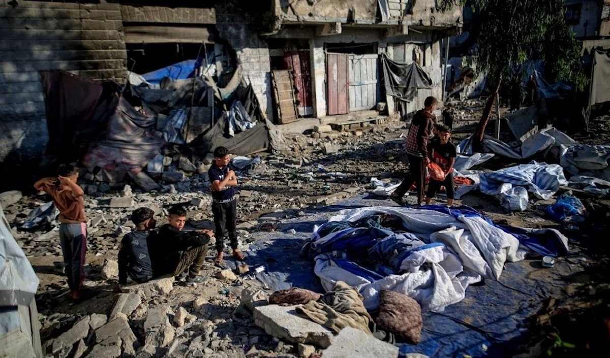 فلسطينيون يتفقدون الدمار الذي خلّفه قصف الاحتلال لمبنى سكني في حي الرمال (من الويب)