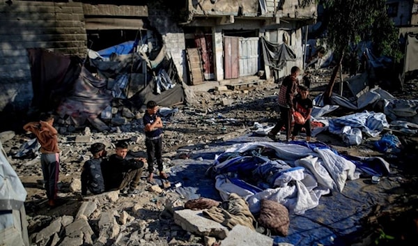 فلسطينيون يتفقدون الدمار الذي خلّفه قصف الاحتلال لمبنى سكني في حي الرمال (من الويب)