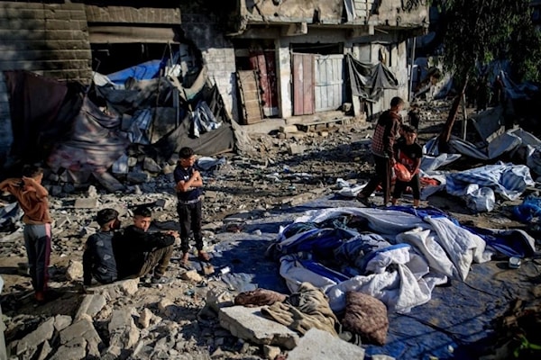 فلسطينيون يتفقدون الدمار الذي خلّفه قصف الاحتلال لمبنى سكني في حي الرمال (من الويب)