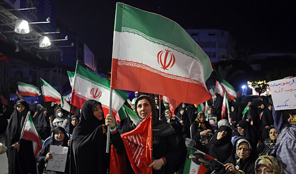 إيرانيات يرفعن علم بلادهن خلال احتجاج مناهض للولايات المتحدة وإسرائيل في طهران (أ ف ب)