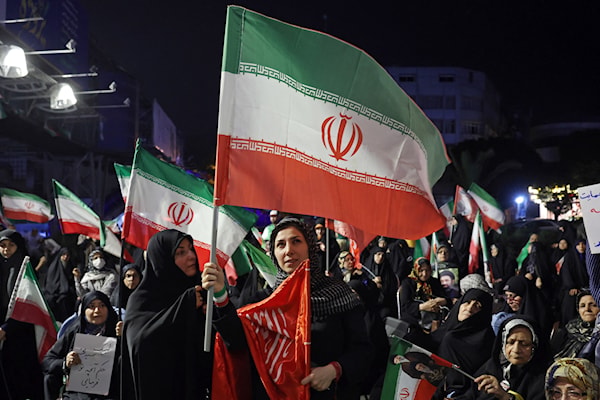 إيرانيات يرفعن علم بلادهن خلال احتجاج مناهض للولايات المتحدة وإسرائيل في طهران (أ ف ب)
