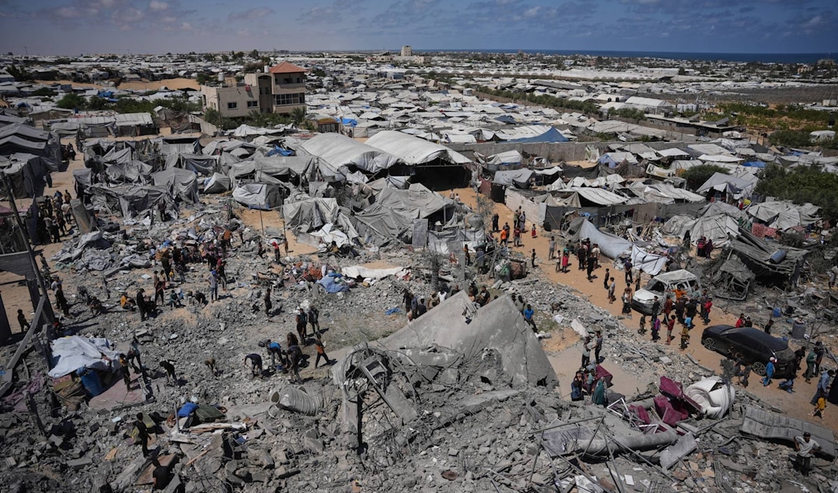 غزّيون يتفّقدون أنقاض مبنى دمّرته غارة جوية إسرائيلية في خانيونس جنوب القطاع (من الويب)