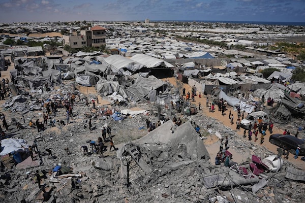 غزّيون يتفّقدون أنقاض مبنى دمّرته غارة جوية إسرائيلية في خانيونس جنوب القطاع (من الويب)