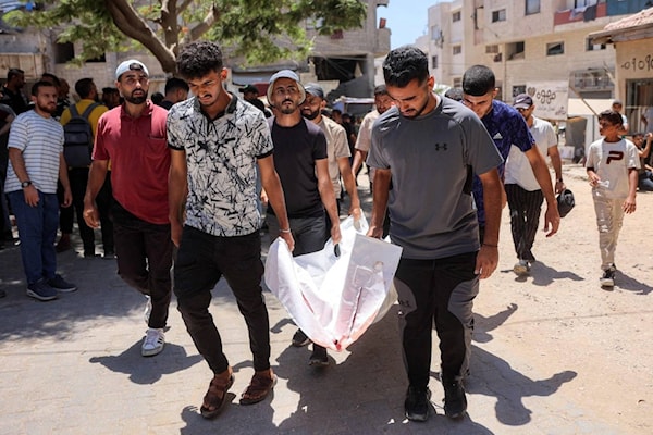 نقل جثمان أحد ضحايا الاستهداف الإسرائيلي لمقرّ شرطة مخيم جباليا (أ ف ب)
