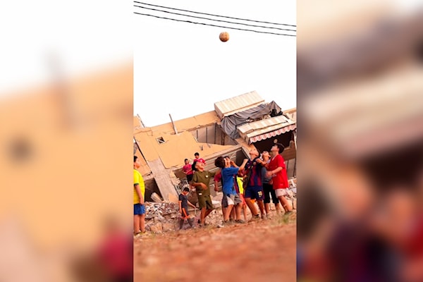 أطفال يلعبون كرة القدم أمام مبنى مدمر في بلدة كفررمان (الأخبار)