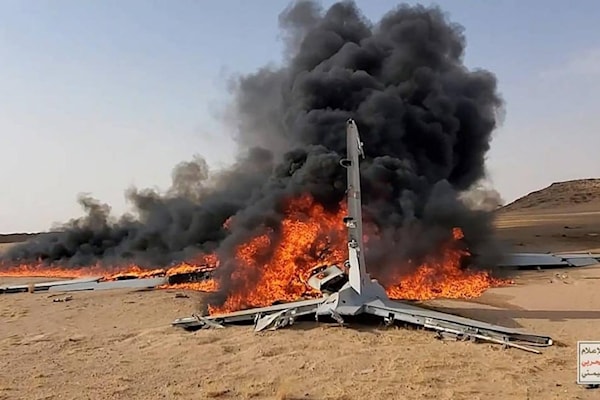 حطام طائرة مسيّرة سعودية يشتعل بعد أن أسقطها اليمنيون في محافظة الجوف (أ ف ب)