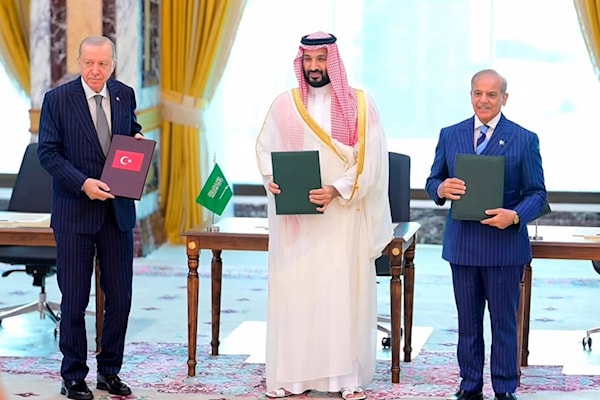القادة الثلاثة، يحملون وثائق «اتفاقية مكة للدفاع المشترك» عقب التوقيع (أ ف ب)
