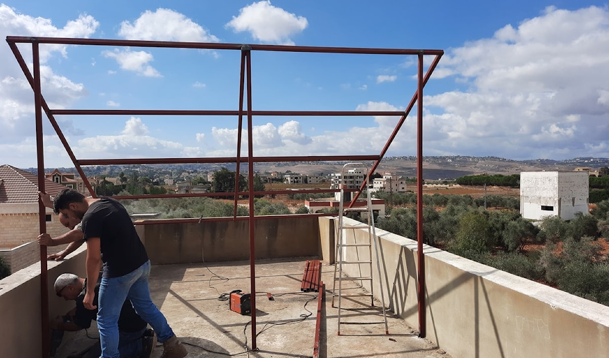 عمال يقومون بتركيب هياكل حديدية لألواح الطاقة الشمسية (الأخبار)