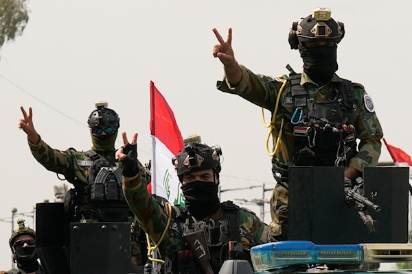 رجال أمن عراقيون يحتفلون برحيل قوات «التحالف» في بغداد (أ ف ب)